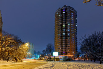 城市景观高层住宅公寓建筑对的背景的蓝色的《暮光之城》的冬天天空和的城市街的晚上公园高层公寓建筑对的背景城市街冬天城市晚上公园覆盖与雪对背景蓝色的《暮光之城》
