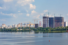 的建设现代住宅建筑上升以上的宽表面的河对的背景的城市景观复制空间城市景观新住宅建筑是被建的银行的Dnipro河