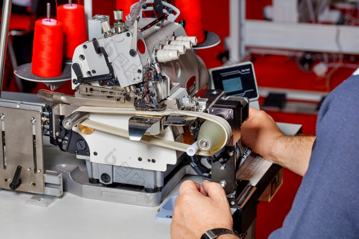 缝纫生产手和工匠集现代电缝纫机和检查的质量它的工作的主使的调整的工作现代电缝纫机