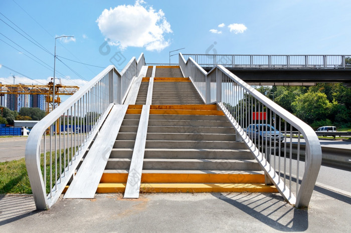 楼梯会行人桥天桥和穿越在高速高速公路明亮的阳光明媚的一天对的背景蓝色的天空与云复制空间高层楼梯过渡的其他一边的高速公路