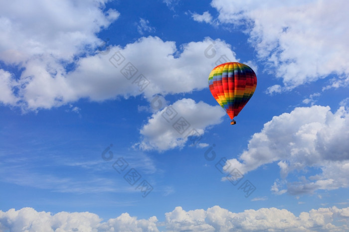 飞行美丽的五彩缤纷的热空气气球与篮子游客的背景的蓝色的天空以上的白色云复制空间马特里五彩缤纷的热空气气球提出了篮子与游客的蓝色的天空在白色云