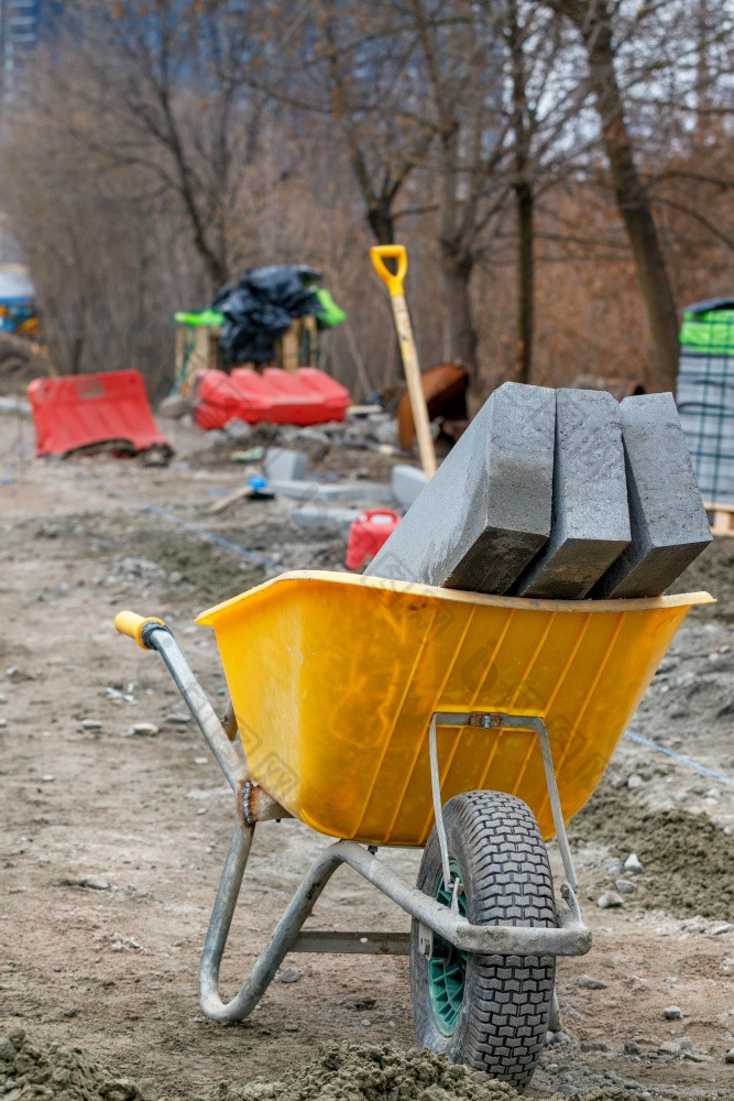 抑制混凝土块谎言内部建设独轮手推车建设网站铺平道路人行道上对的背景工作场所模糊垂直图像复制空间混凝土抑制块谎言内部建设独轮手推车对的背景工作场所模糊