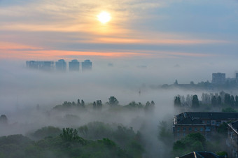 厚雾就像羽绒被传播早期的早....之间的的房子和树的城市公园的软触摸的不断<strong>上升</strong>的太阳的射线的不断<strong>上升</strong>的太阳的早期早....轻轻之后的睡觉城市覆盖与厚雾就像羽绒被