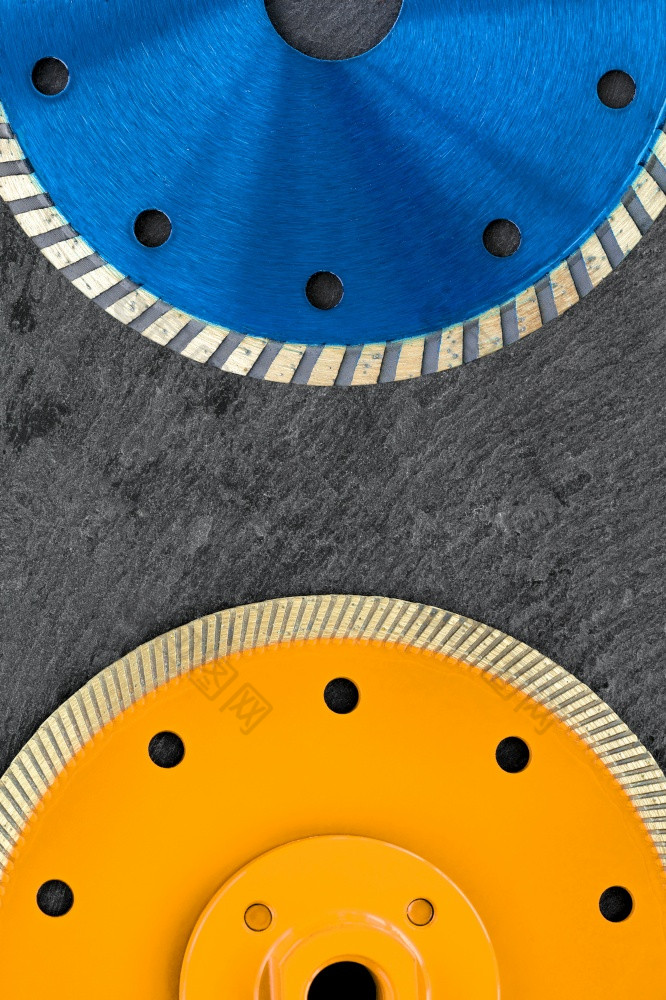 以上部分的蓝色的钻石切割轮和下面部分的黄色的钻石切割轮为切割和处理石头混凝土和钢筋混凝土复制空间垂直图像片段蓝色的和黄色的钻石切割轮是位于对的背景灰色的花岗岩特写镜头垂直图像