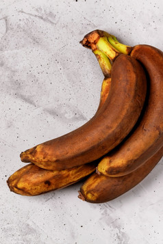 丑陋的棕色（的）过熟的香蕉灰色的混凝土背景平躺复制空间垂直图像丑陋的成熟的香蕉灰色的混凝土背景