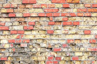 纹理老红色的砖墙与众多损害赔偿和碎片砖砌的老砖墙摇摇欲坠状态与片段砖砌的