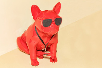 红色的玩具警卫狗坐着它的后腿与黑色的眼镜和隐藏的<strong>监测</strong>相机它的额头米色墙背景复制空间很酷的小雕像红色的警卫狗与黑色的眼镜和隐藏的<strong>监测</strong>相机他的额头