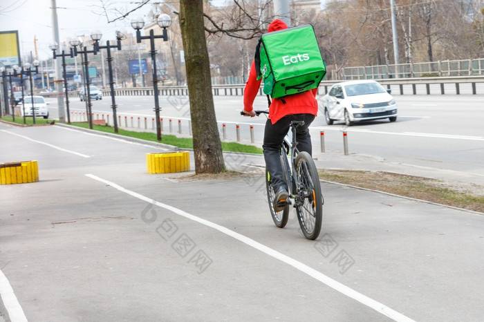 快递与绿色等温背包后面他的回来游乐设施沿着的人行道上城市街自行车现代食物交付概念cpoy空间快递与等温绿色背包他的回来食物交付自行车城市街
