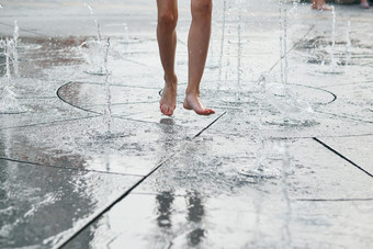 孩子站跳玩喷泉而热天气特写镜头腿水流溅坦诚的人真正的时刻真实的的情况下