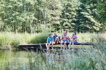 家庭支出时间在一<strong>起坐</strong>着桥在湖在的树关闭自然在夏天假期坦诚的人真正的时刻真实的的情况下