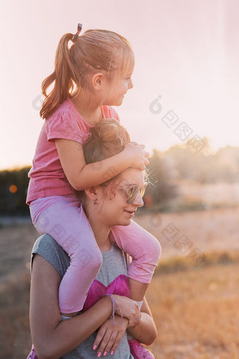 姐妹享受肩扛<strong>骑</strong>十几岁的女孩携带她的年轻的妹妹的回来和<strong>肩膀</strong>支出时间玩在一起在户外的农村坦诚的人真正的时刻真实的的情况下