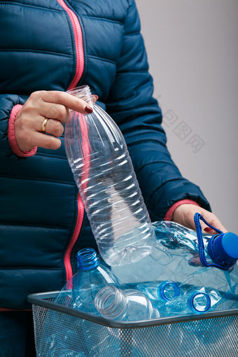 女人扔出使用<strong>塑料</strong>瓶和包装垃圾本收集空<strong>塑料</strong>压扁瓶蓝色的袋<strong>塑料</strong>浪费回收概念<strong>塑料</strong>污染和太许多<strong>塑料</strong>浪费