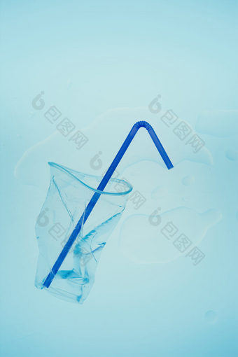 压扁塑料杯和喝稻草在蓝色的背景收集塑料浪费回收概念塑料污染和太许多塑料浪费复制空间的前