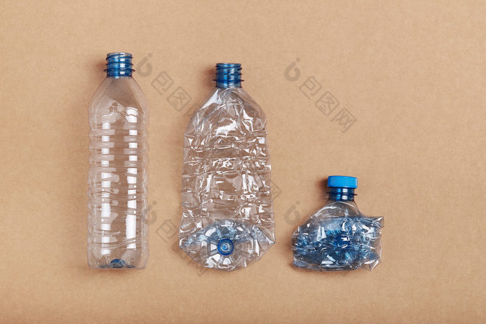 压扁空塑料瓶把行在纸板背景收集塑料浪费回收概念塑料污染和太许多塑料浪费复制空间为文本