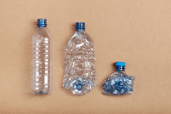 压扁空塑料瓶把行在纸板背景收集塑料浪费回收概念塑料污染和太许多塑料浪费复制空间为文本