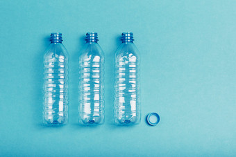 空塑料瓶杯和帽在蓝色的背景收集塑料浪费回收概念塑料污染和太许多塑料浪费复制空间的前