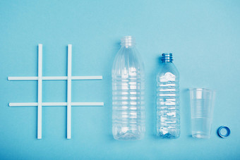 标签回收空塑料瓶杯和瓶帽把行后标签在蓝色的背景收集塑料浪费回收概念塑料污染和太许多塑料浪费复制空间的前
