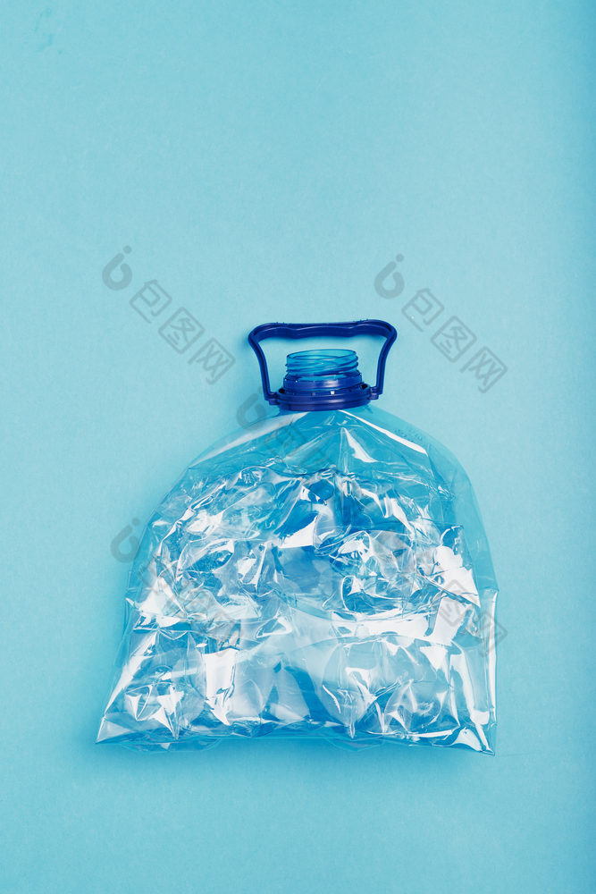 压扁空塑料瓶在蓝色的背景收集塑料浪费回收概念塑料污染和太许多塑料浪费复制空间的前