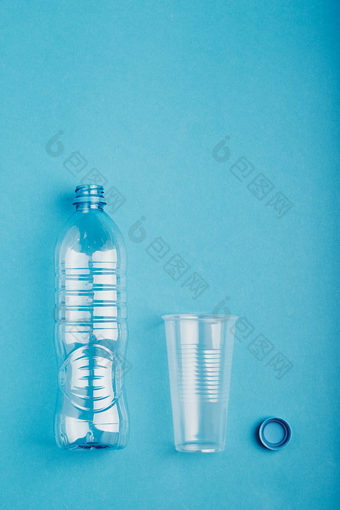 空塑料瓶杯和帽在蓝色的背景收集塑料浪费回收概念塑料污染和太许多塑料浪费复制空间的前