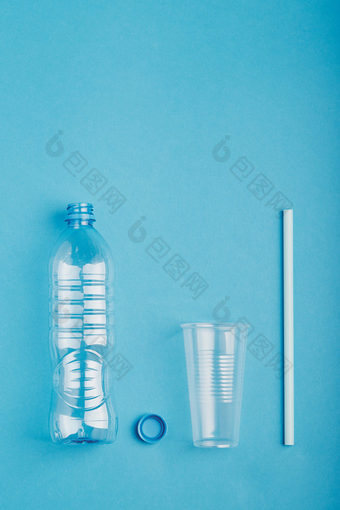 空塑料瓶杯稻草和帽在蓝色的背景收集塑料浪费回收概念塑料污染和太许多塑料浪费复制空间的前