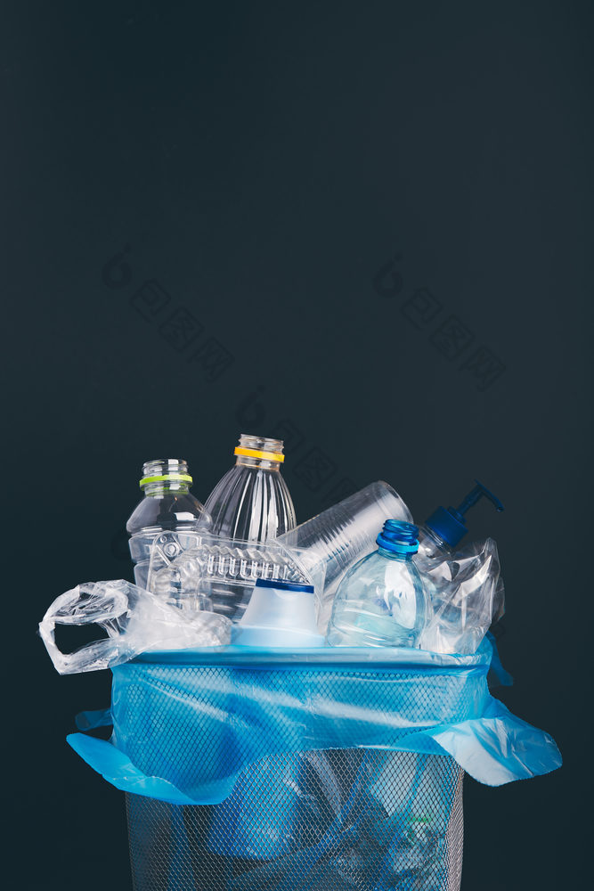 堆塑料瓶杯袋收集回收金属本概念塑料污染和太许多塑料浪费垃圾与使用塑料包装在黑暗蓝色的背景与复制空间的前