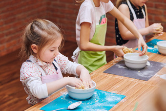 小女孩揉捏的面团为烘焙的蛋糕孩子们采取部分烘焙车间烘焙类为孩子们有抱负的小厨师学习烹饪结合和激动人心的准备成分真正的人真实的的情况下