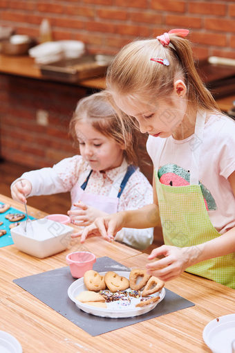 小女孩装修烤饼干与色彩斑斓的撒上和糖衣糖孩子们采取部分烘焙车间烘焙类为孩子们有抱负的小厨师学习烹饪结合和激动人心的准备成分真正的人真实的的情况下