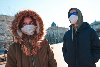 年轻的女人和男人。的抽油烟机穿的脸面具避免病毒感染和防止的传播疾病人走城市中心病毒感染保护真正的人真实的的情况下