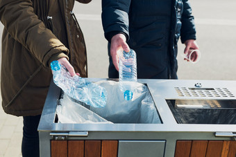女人和男人。扔塑料瓶垃圾塑料浪费回收概念塑料污染和回收塑料浪费环境问题环境损害真正的人真实的的情况下
