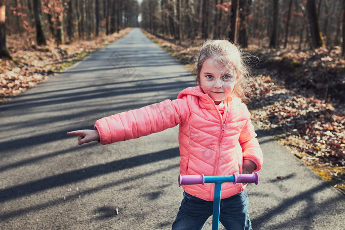 小女孩玩的公园骑踏板车有有趣的阳光明媚的秋天一天真正的人真实的的情况下