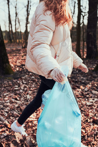 年轻的女人清洁森林志愿者挑选塑料浪费袋概念塑料污染和太许多塑料浪费<strong>环境</strong>问题<strong>环境</strong>损害责任为<strong>环境</strong>真正的人真实的的情况下