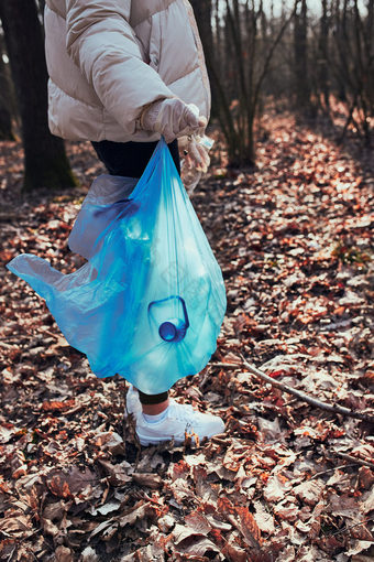 年轻的女人清洁森林志愿者挑选塑料浪费袋概念塑料污染和太许多塑料浪费<strong>环境</strong>问题<strong>环境</strong>损害责任为<strong>环境</strong>真正的人真实的的情况下