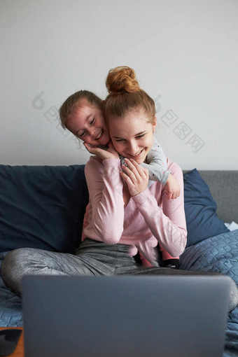 孙子十几岁的女孩和她的年轻的妹妹会说话的视频调用与granparents移动<strong>PC</strong>从<strong>首页</strong>在<strong>新</strong>冠病毒检疫女孩坐着床上前面电脑