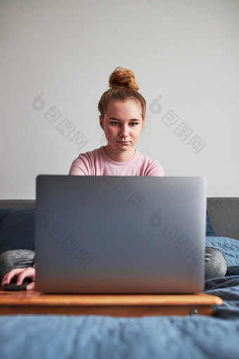 十几岁的女孩工作学校任务家庭作业远程她的移动PC从首页在新冠病毒检疫在线课程教训学习远程女孩坐着床上前面电脑看屏幕