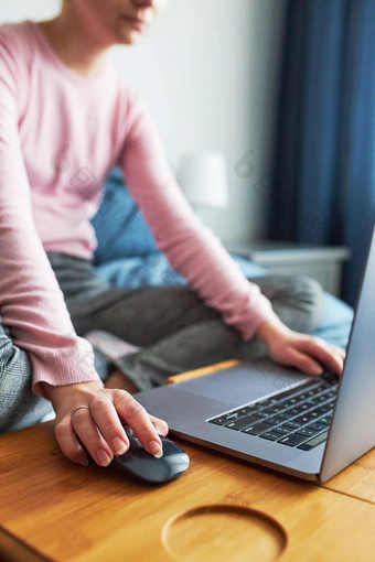 十几岁的女孩工作学校任务远程她的移动PC从首页在新冠病毒检疫在线课程教训学习远程女孩坐着床上前面电脑看屏幕