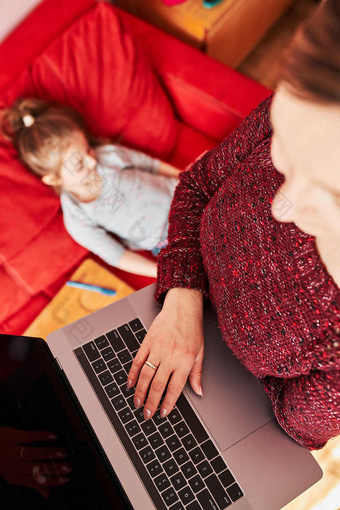 女人妈妈。工作做她的工作远程在视频闲谈，聊天调用流在线<strong>课程网络</strong>研讨会移动PC从首页在新冠病毒检疫而她的女儿看视频平板电脑女人坐着床上前面电脑看屏幕