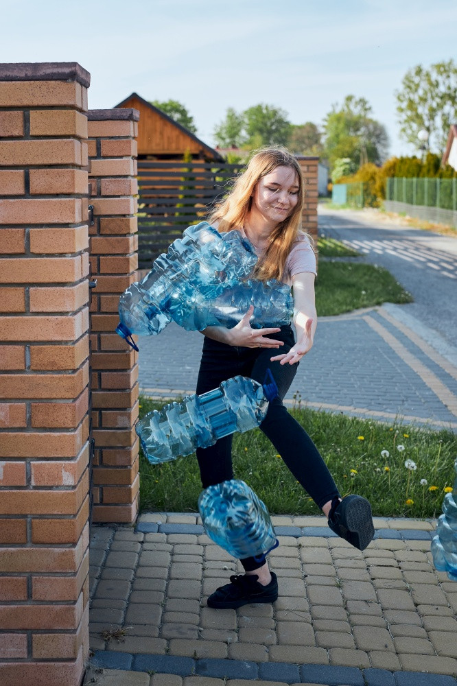 年轻的女人扔出空使用塑料水瓶成垃圾本收集塑料浪费回收概念塑料污染和太许多塑料浪费环境问题
