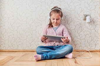 小女孩学龄前儿童学习在线解决谜题玩教育游戏列表音乐和听起来使用平板电脑和headpphones首页在流感大流行检疫
