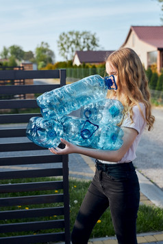 年轻的女人扔出空使用塑料水瓶成垃圾本收集塑料浪费回收概念塑料污染和太许多塑料浪费环境问题