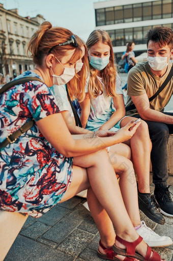 家庭支出时间在一起坐着的城市中心女孩穿的脸面具避免病毒感染和防止的传播疾病时间冠状病毒