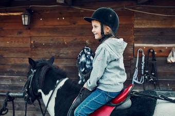 小微笑女孩学习马背上的骑年老马术头盔有有趣的骑马小微笑女孩学习马背上的骑
