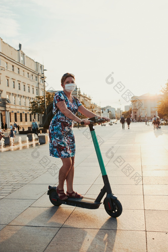 年轻的女人骑电踏板车的城市中心女人穿的脸面具避免病毒感染和防止的传播疾病时间冠状病毒坦诚的人真正的时刻真实的的情况下