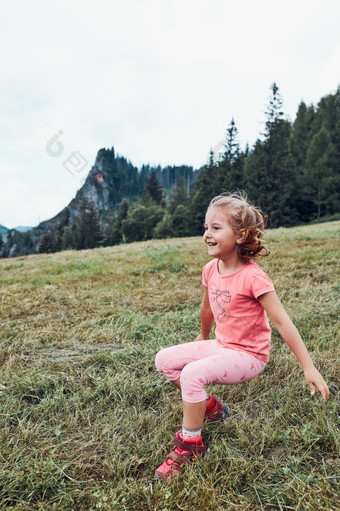 小女孩铺设玩草享受夏天一天快乐孩子玩的场在<strong>假</strong>期旅行山山<strong>景观</strong>的背景小女孩铺设玩草享受夏天一天在<strong>假</strong>期旅行