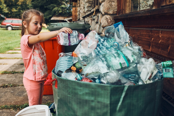 孩子小女孩扔出塑料瓶大容器完整的塑料浪费孩子小女孩扔出塑料瓶大容器填满与塑料浪费
