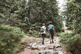 家庭与背包徒步旅行山积极支出夏天假期在一起走森林路径会说话的和欣赏自然山风景家庭与背包徒步旅行山积极支出夏天假期在一起