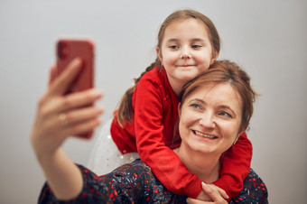妈妈。与她的小女儿使视频调用<strong>使用移动电话</strong>保持距离女人和小女孩会说话的与亲戚快乐的家庭有有趣的采取自拍照片<strong>使用</strong>智能手机连接远程与家庭