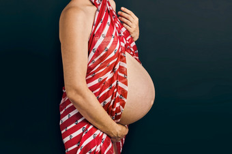 怀孕了女人触碰她的肚子站在平原背景怀孕期望母亲概念