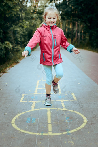 活跃的小女孩玩跳房子操场上在户外跳为<strong>快乐孩子</strong>们户外活动