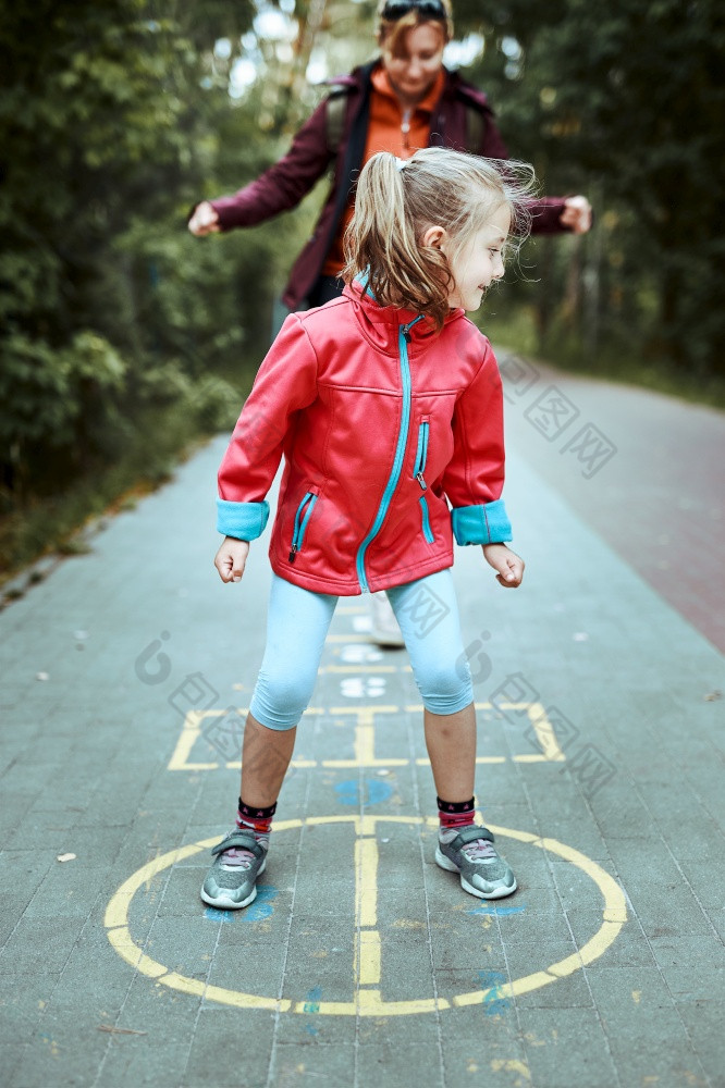 活跃的小女孩玩跳房子操场上在户外跳为快乐孩子们户外活动