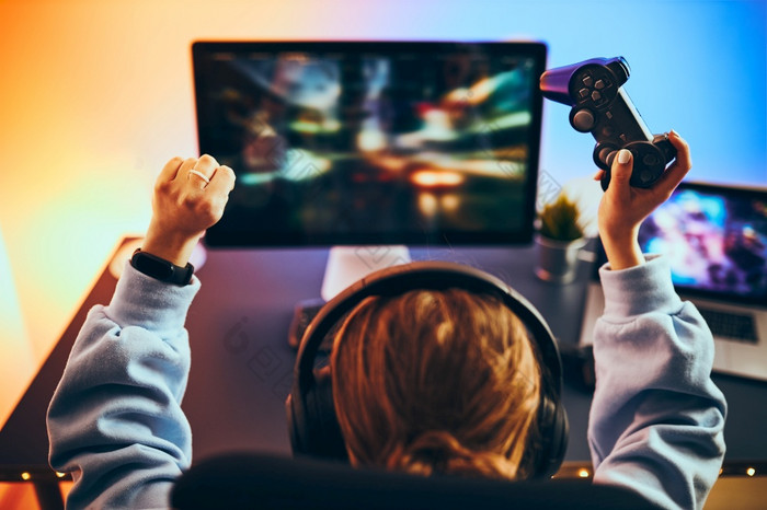 少年女孩玩视频游戏首页玩家持有游戏手柄坐着前面屏幕彩带玩在线黑暗房间基斯霓虹灯灯竞争和有有趣的